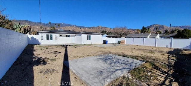 rear view of house featuring a mountain view and a patio area