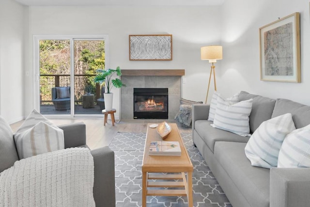 living room featuring a tiled fireplace and hardwood / wood-style floors