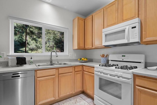 kitchen featuring light brown cabinetry, sink, white appliances, and light tile patterned flooring