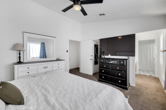 carpeted bedroom featuring ensuite bath, ceiling fan, and vaulted ceiling