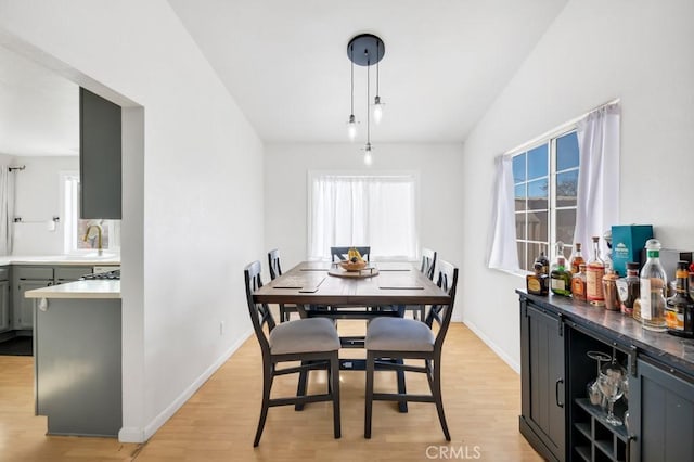 dining area featuring light hardwood / wood-style floors, a healthy amount of sunlight, and sink