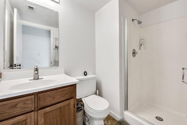 bathroom featuring vanity, toilet, and an enclosed shower