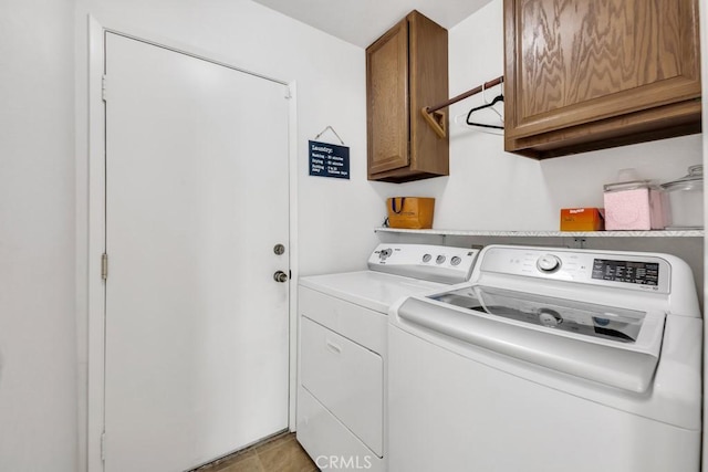 washroom featuring washer and dryer, light tile patterned flooring, and cabinets