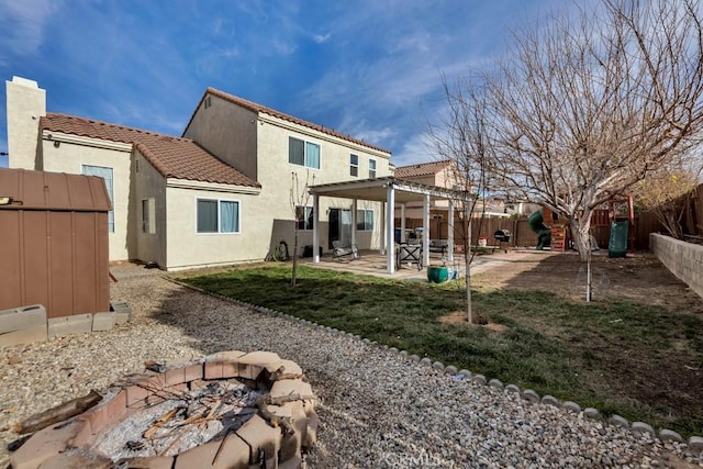 rear view of house with a patio, a shed, and an outdoor fire pit