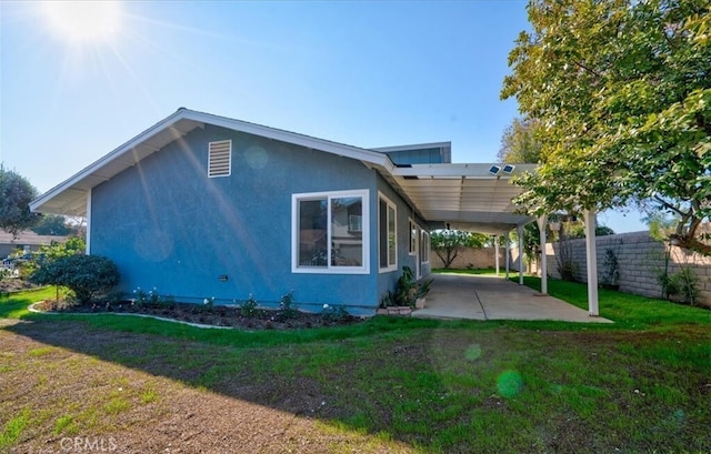 back of property featuring a yard and a carport