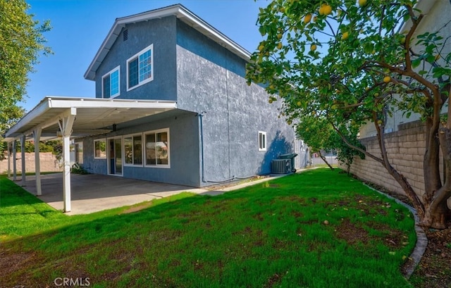 rear view of house featuring a lawn, cooling unit, and a patio