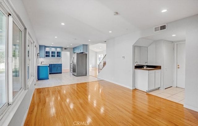 unfurnished living room featuring light hardwood / wood-style flooring and sink