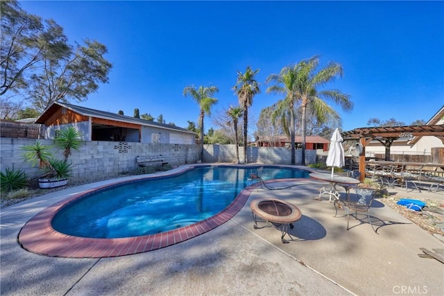 view of swimming pool featuring a patio, a pergola, and a fire pit