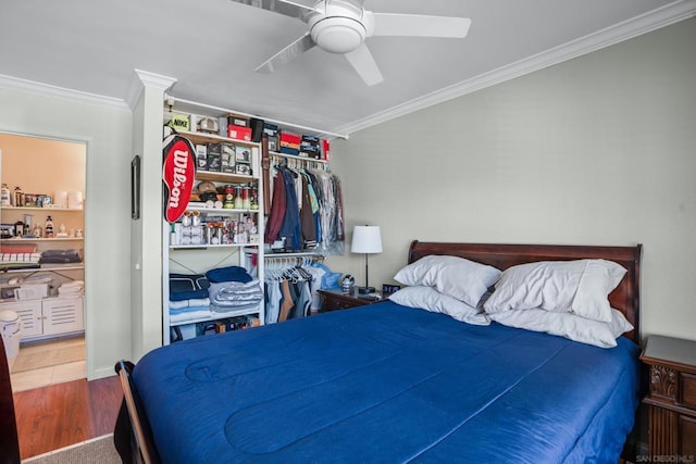 bedroom featuring ceiling fan, a closet, hardwood / wood-style floors, and ornamental molding