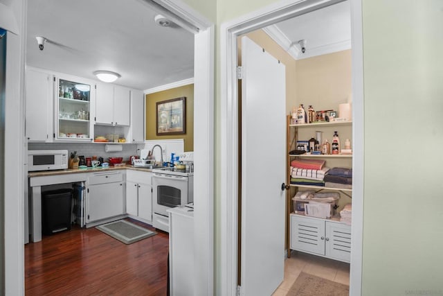 kitchen with white appliances, white cabinetry, ornamental molding, and backsplash