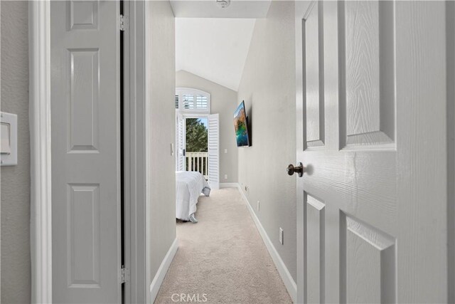 hallway featuring light carpet and lofted ceiling