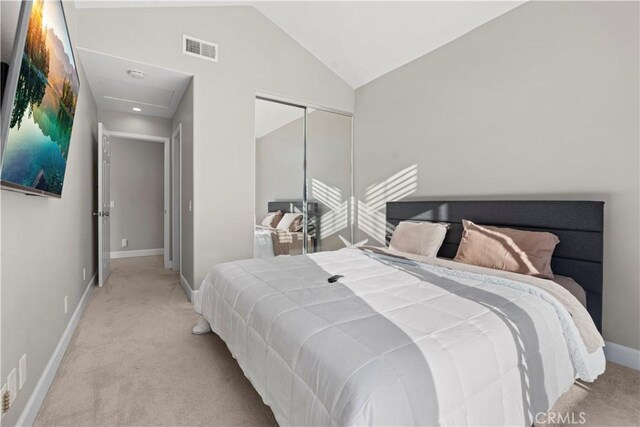 carpeted bedroom featuring vaulted ceiling and a closet