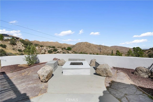 view of patio / terrace featuring a fire pit and a mountain view