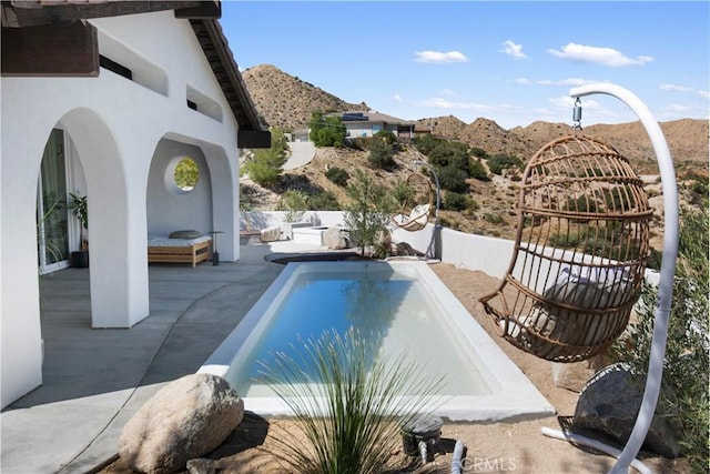 view of swimming pool featuring a patio area and a mountain view