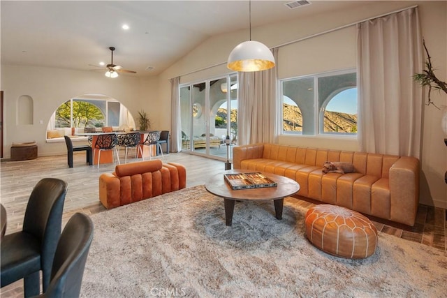 interior space featuring ceiling fan, wood-type flooring, a wealth of natural light, and vaulted ceiling