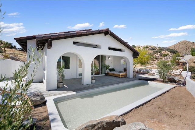 rear view of property featuring a mountain view and a patio area