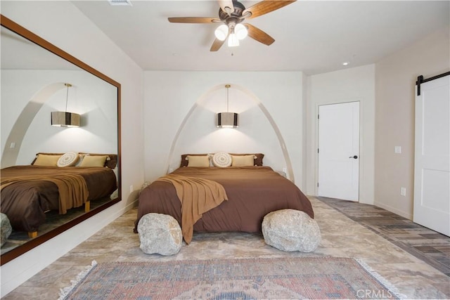 bedroom featuring a barn door and ceiling fan