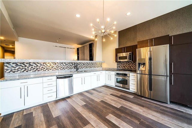 1100 Wilshire Blvd Unit 2707, Los Angeles, CA 90017 - kitchen with dark hardwood / wood-style floors, decorative backsplash, a notable chandelier, white cabinetry, and stainless steel appliances