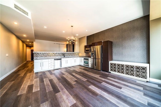 1100 Wilshire Blvd Unit 2707, Los Angeles, CA 90017 - kitchen with tasteful backsplash, dark hardwood / wood-style flooring, decorative light fixtures, and appliances with stainless steel finishes