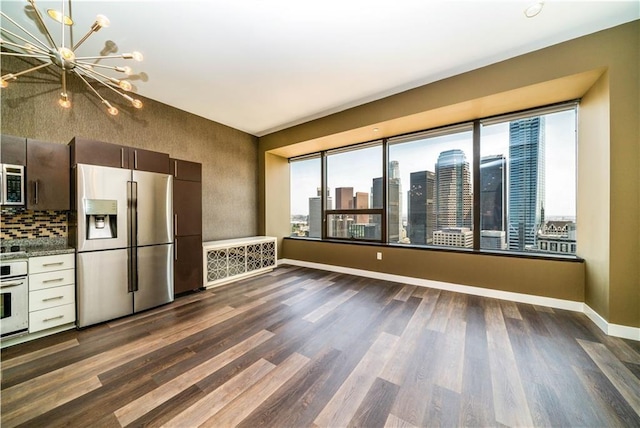 kitchen featuring white oven, stainless steel fridge with ice dispenser, dark hardwood / wood-style flooring, and a chandelier