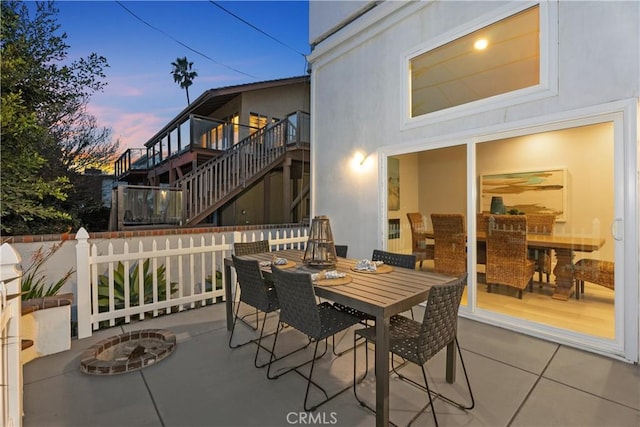 patio terrace at dusk featuring a fire pit