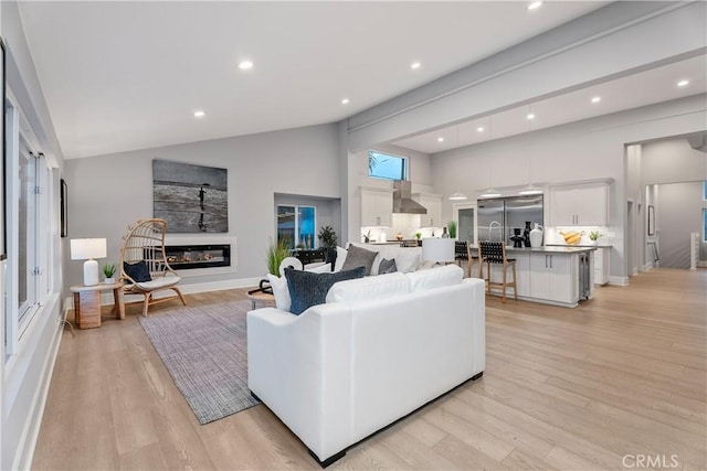 living room featuring light wood-type flooring and lofted ceiling