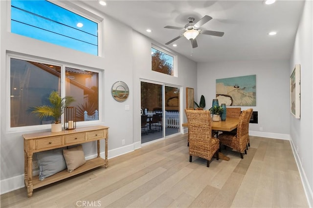 dining space with high vaulted ceiling, light hardwood / wood-style flooring, and ceiling fan