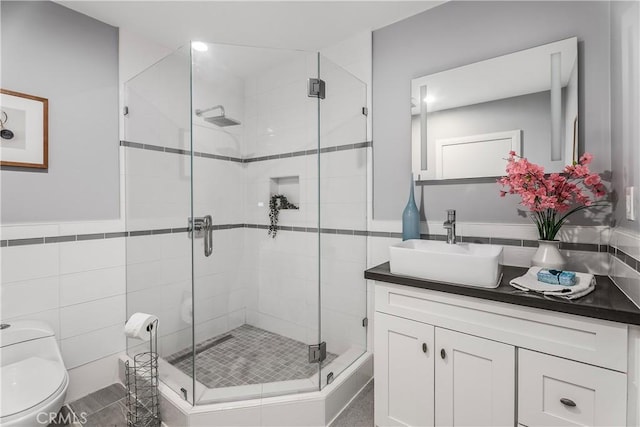 bathroom featuring toilet, vanity, and an enclosed shower