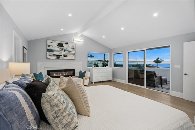 bedroom featuring hardwood / wood-style flooring, a water view, access to outside, and lofted ceiling with beams