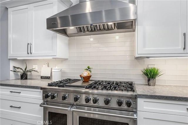 kitchen featuring white cabinetry, backsplash, double oven range, and extractor fan