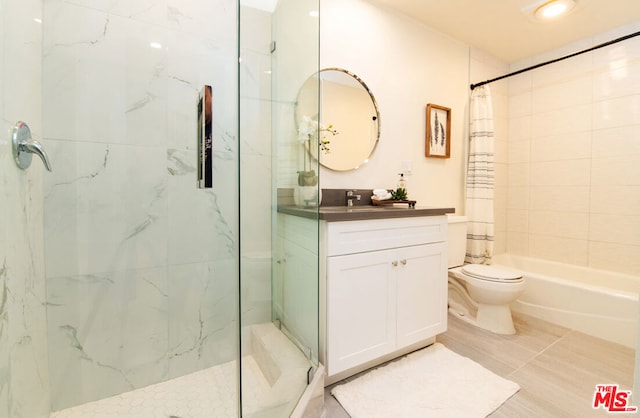 bathroom featuring tile patterned floors, vanity, toilet, and tiled shower