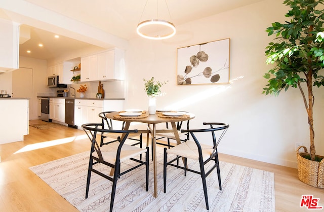 dining area with light hardwood / wood-style flooring and sink