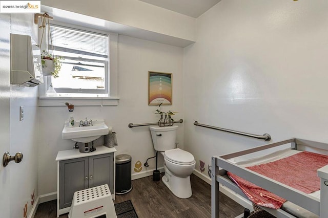 bathroom featuring wood-type flooring, toilet, and sink