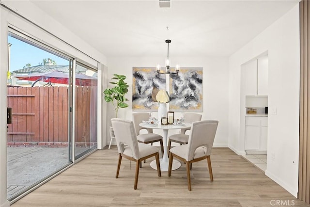 dining area featuring light wood-type flooring and a chandelier