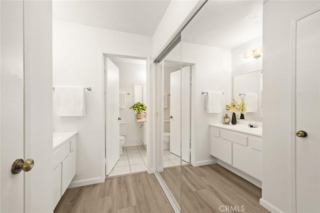 bathroom featuring toilet, vanity, and wood-type flooring