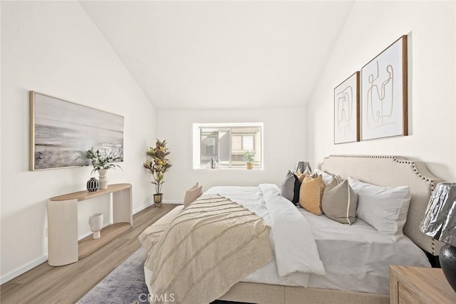 bedroom with light hardwood / wood-style floors and vaulted ceiling