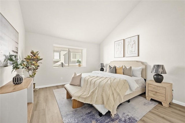 bedroom with lofted ceiling and light wood-type flooring