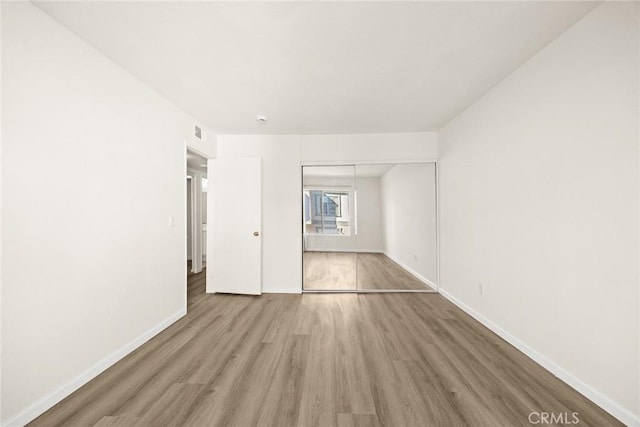 unfurnished bedroom featuring a closet and hardwood / wood-style flooring