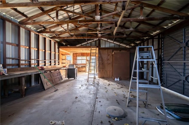 misc room with concrete flooring and vaulted ceiling