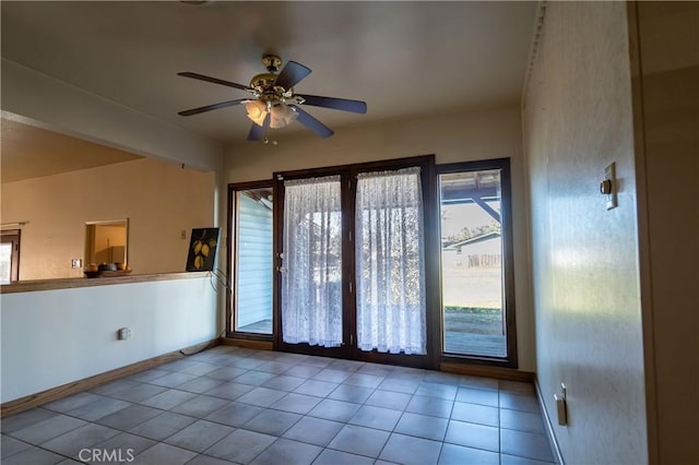 tiled spare room with ceiling fan