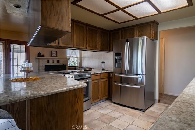 kitchen with stainless steel appliances, light tile patterned flooring, plenty of natural light, and kitchen peninsula