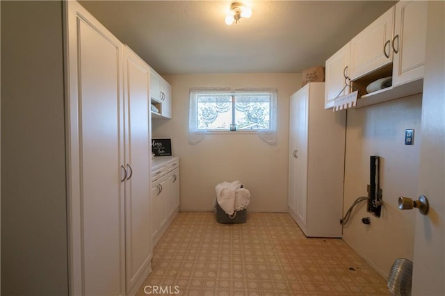 clothes washing area featuring cabinets