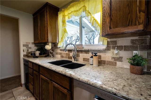 kitchen with sink, light tile patterned floors, dishwasher, backsplash, and light stone countertops