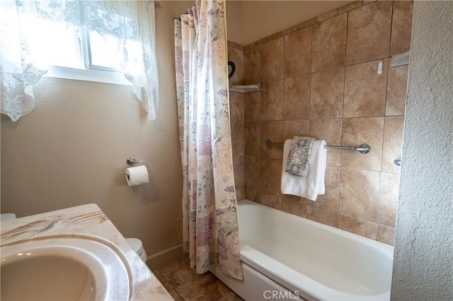 full bathroom with sink, tile patterned floors, toilet, and shower / bath combo with shower curtain