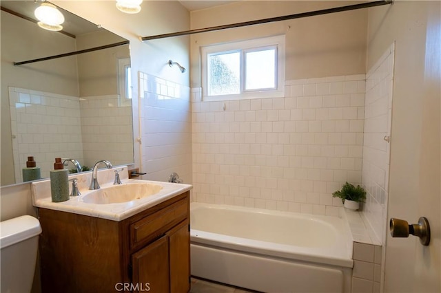 full bathroom with tiled shower / bath combo, vanity, and toilet