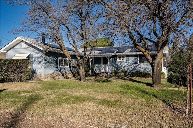 single story home with a front yard and solar panels