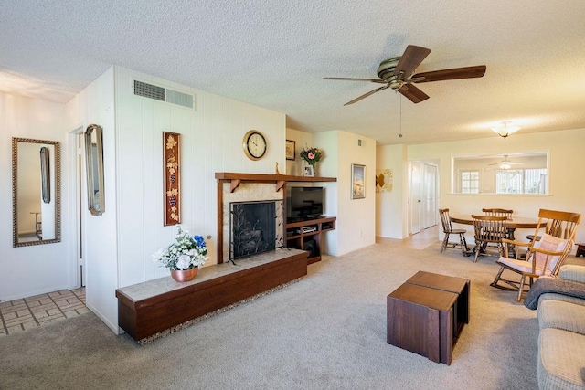 living room with ceiling fan, light colored carpet, and a textured ceiling