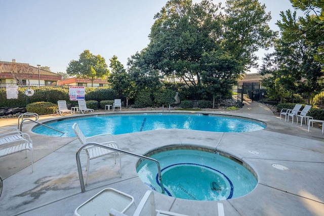 view of pool featuring a patio and a hot tub