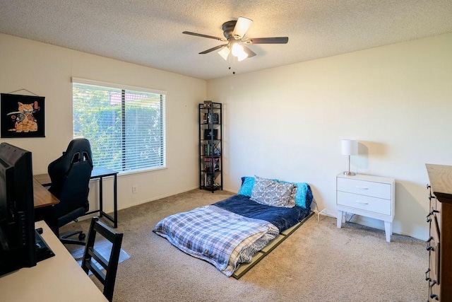 bedroom featuring ceiling fan, light colored carpet, and a textured ceiling