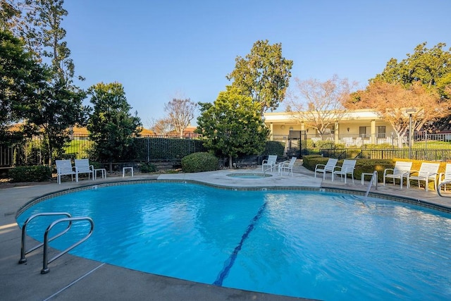 view of swimming pool with a patio and a hot tub